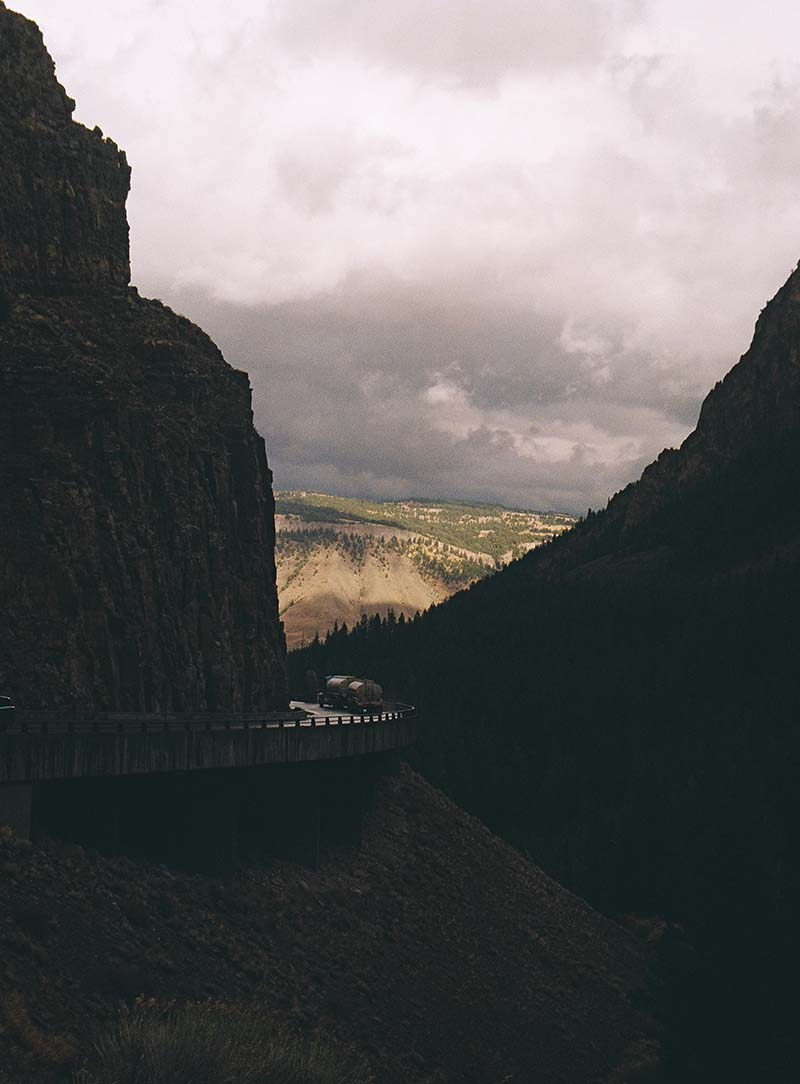 gas truck next to mountain side between mountains